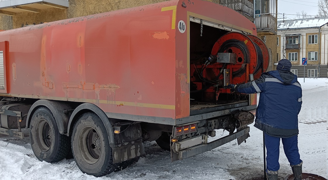 Каналопромывочная машина и работник прочищают засор в канализационной системе в Онеге